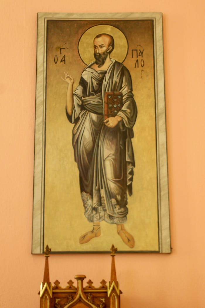 Vertical shot of a religious painting depicting a saint on an interior wall.